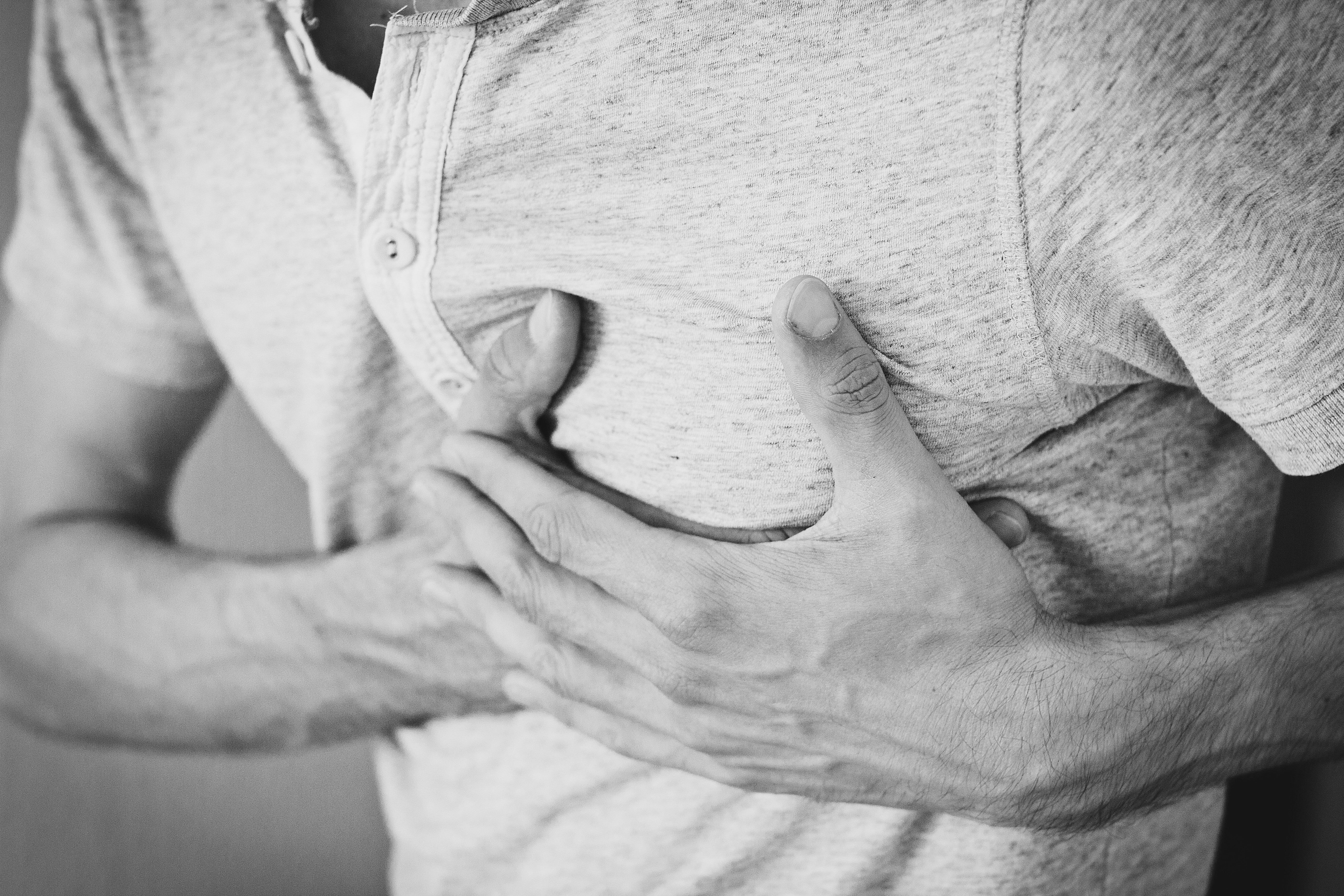 Man clutching his chest in black and white