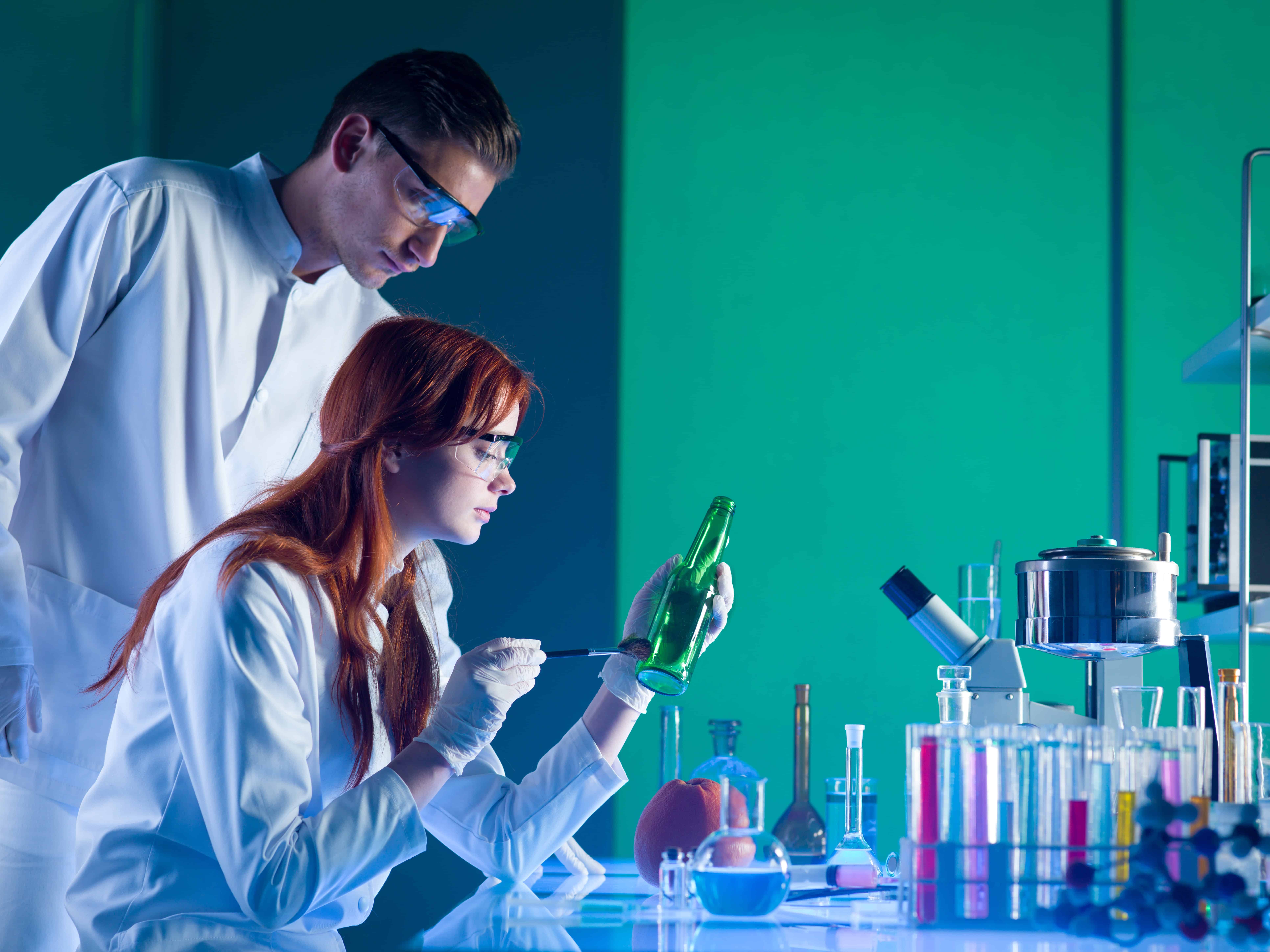 Two forensic scientists examining objects