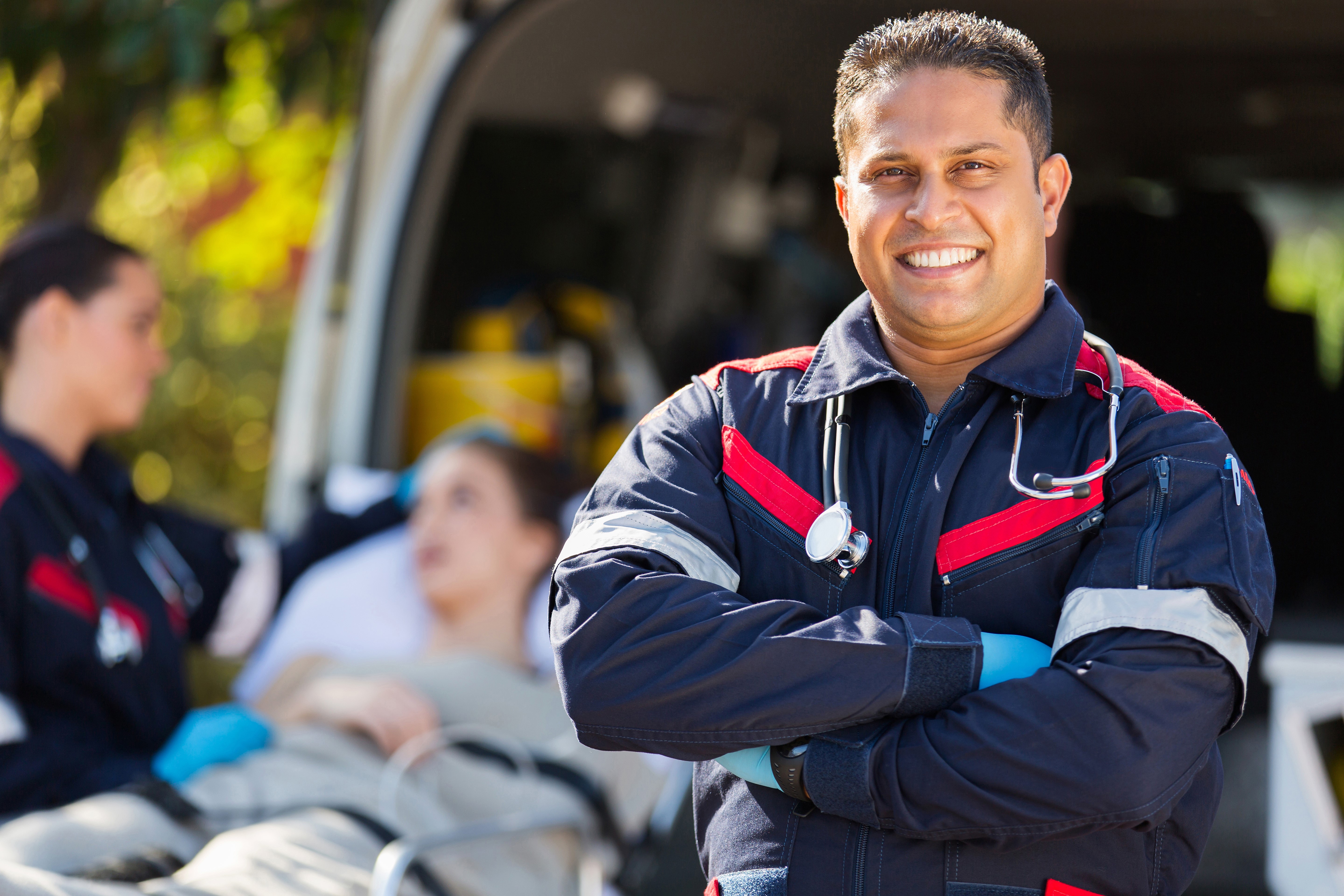 Smiling EMT in front of an ambulance