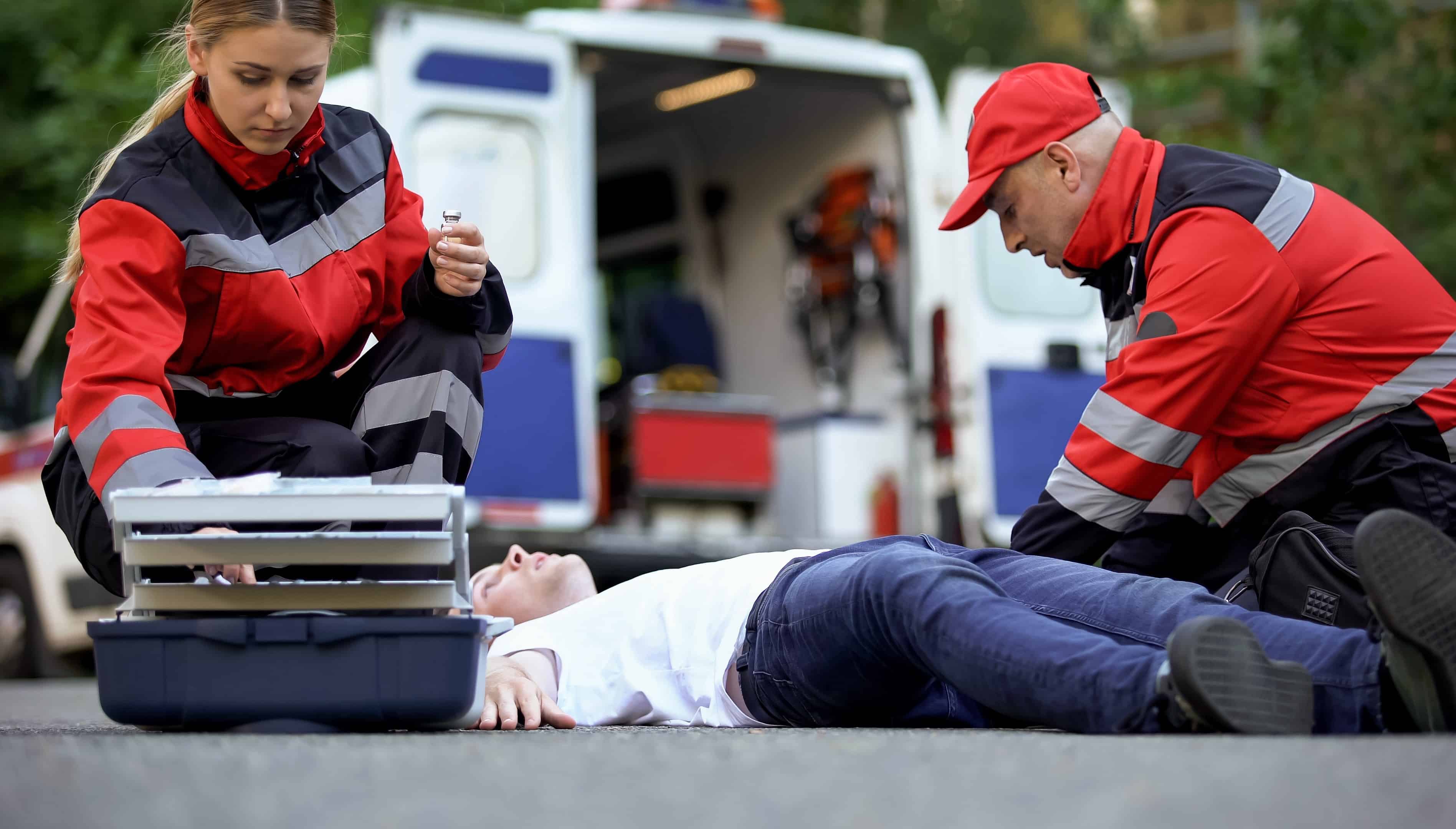 EMS professionals helping a man on the ground