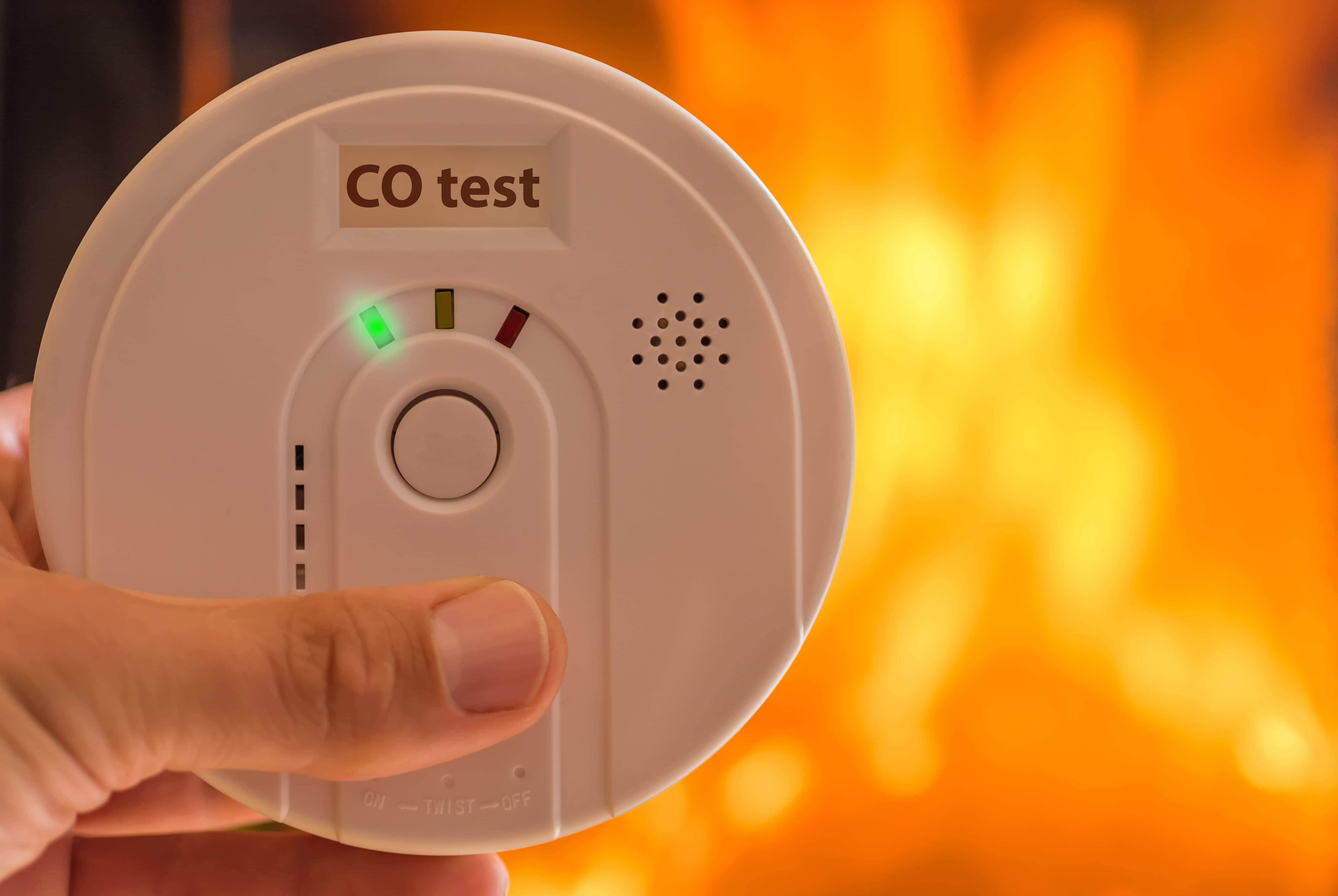 Hand holding a carbon monoxide detector