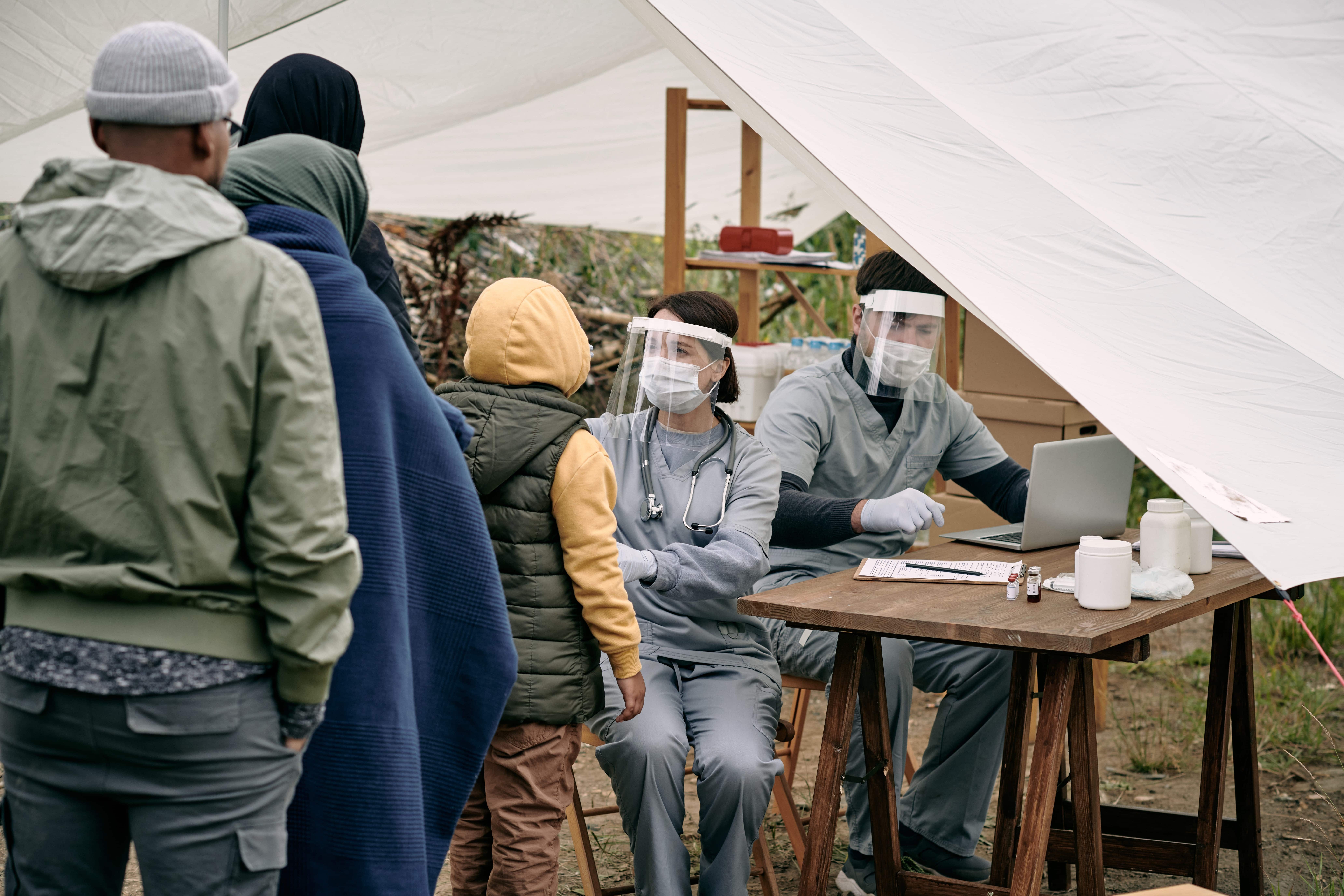 Medical professionals providing care to a line of homeless people