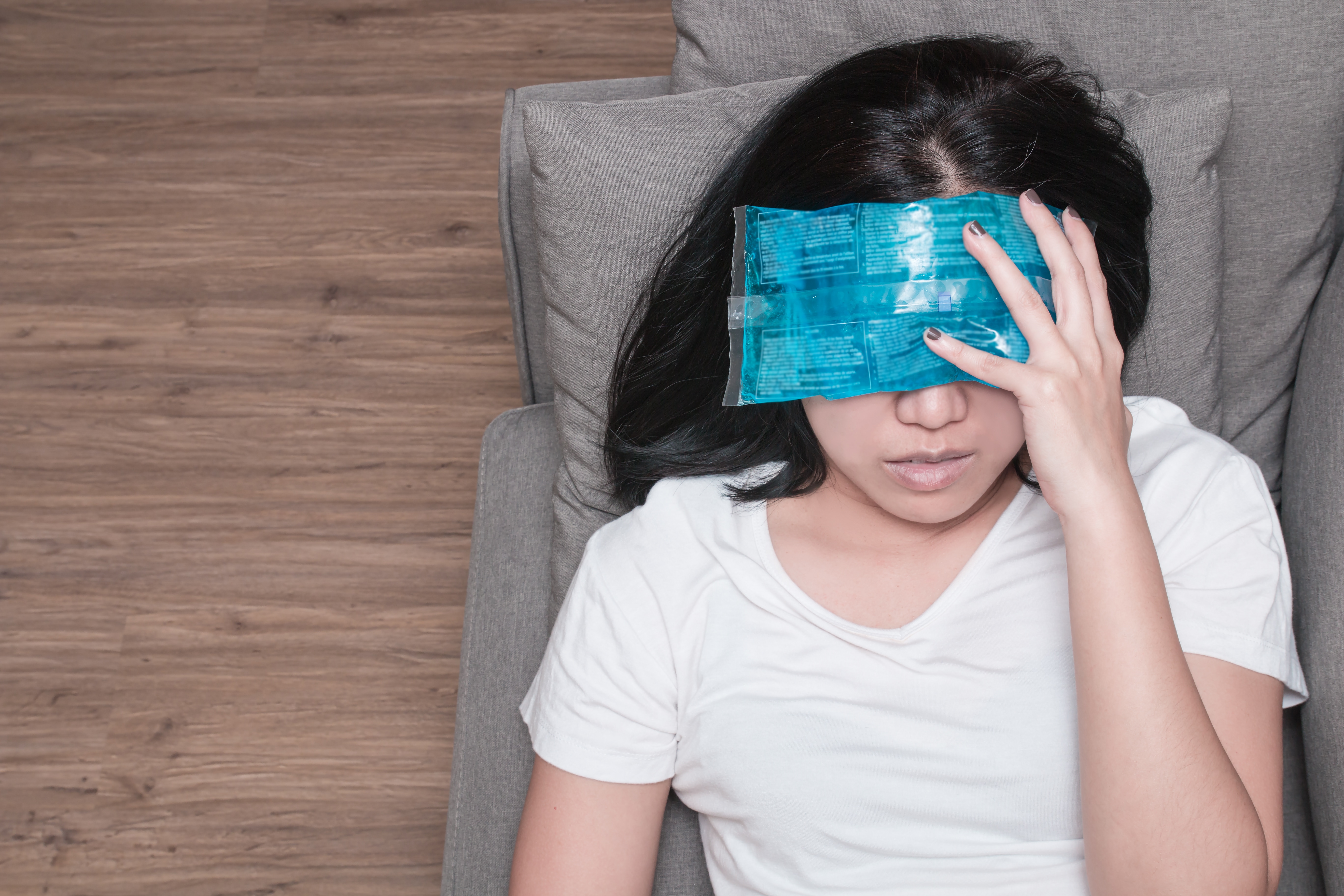 Asian woman holding a cold pack on her head