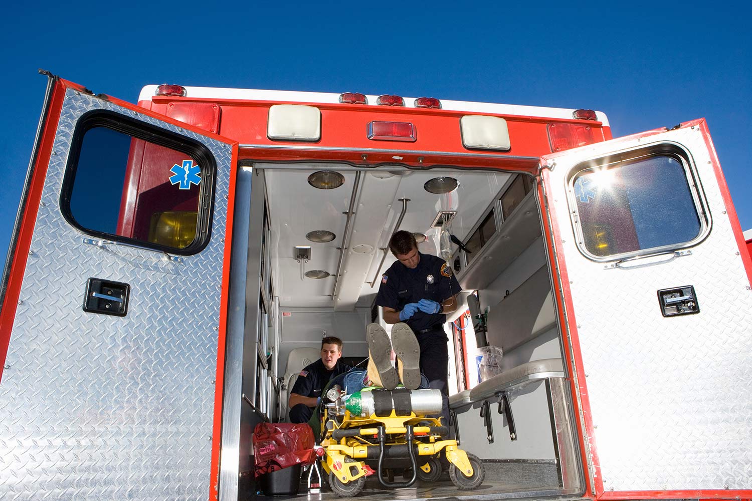 EMS professionals stabilizing a person in an ambulance